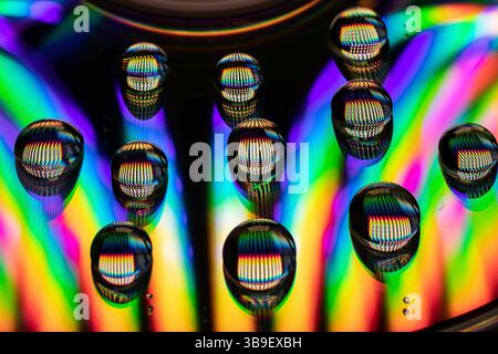 Water drops on a CD create an explosion of colour Stock Photo