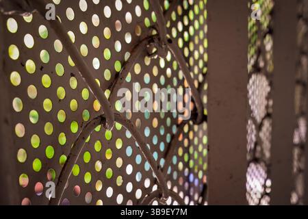 Perforated metal sheet with colorful blurred light background Stock Photo