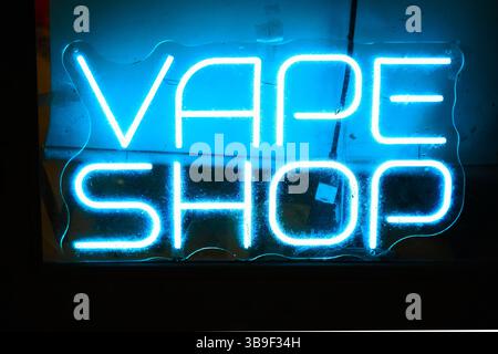 Neon blue Vape Shop sign in smoke shop window Stock Photo