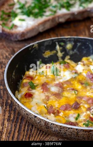 Scrambled eggs in a pan on wood Stock Photo