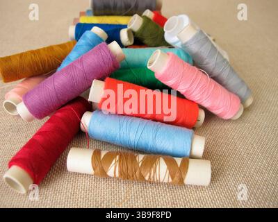 Sewing thread in different colours on fabric Stock Photo