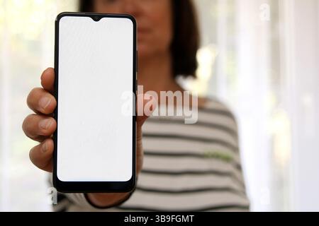 Woman shows the blank display of her mobile phone Stock Photo