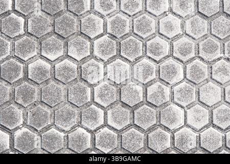 Close-up of a modern pavement featuring hexagonal tile patterns, detailed with subtle gray shades, suitable for backgrounds and urban design themes. Stock Photo