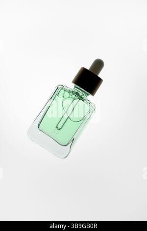 A sleek aloe vera glass dropper bottle with black cap elegantly floats against a pristine white background. Perfect for beauty, skincare, or wellness Stock Photo