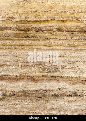 Detailed close-up of natural limestone showcasing horizontal layers and earthy tones. The textured surface forms an abstract pattern, ideal for backgr Stock Photo
