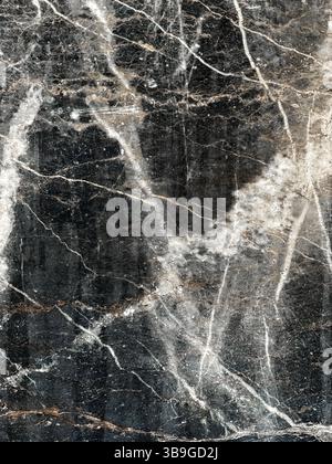 Captivating dark marble texture featuring intricate white and pale veins. Ideal for backgrounds, design inspiration, or architectural elements. Rich a Stock Photo