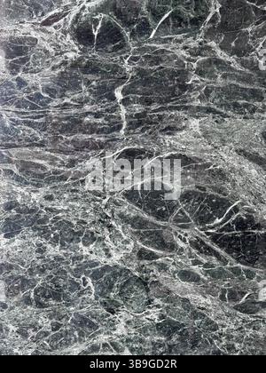 High-resolution image of dark green marble featuring intricate white veins. This elegant stone texture is perfect for backgrounds, designs, and archit Stock Photo