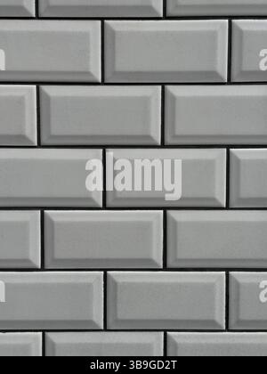 A detailed image of a white brick wall featuring a uniform pattern. The rectangular bricks are neatly aligned, showcasing a clean and minimalist desig Stock Photo