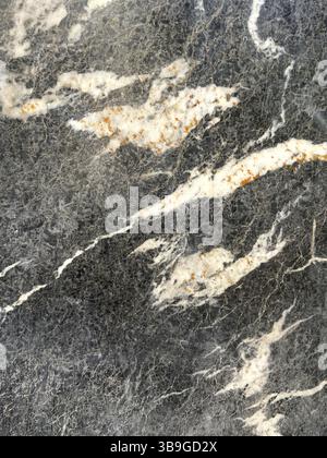 Detailed view of a polished marble surface featuring elegant gray and white swirls and veins. The contrasting colors create a sophisticated and timele Stock Photo