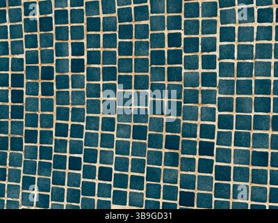 A close-up of a surface adorned with small, blue square tiles arranged in a geometric pattern. The regular grid layout creates a visually appealing mo Stock Photo