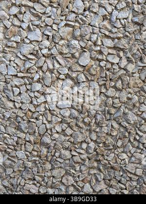 Close-up view of a natural stone wall, showcasing rugged, uneven stones in varying shades of gray. The textured surface highlights the intricate detai Stock Photo