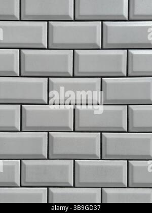 A close-up shot of a gray brick wall showcasing its modern, textured pattern. The bricks are arranged in a classic subway style, adding a touch of ele Stock Photo