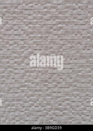 A detailed view of a textured gray wall with a brick pattern. The surface features a subtle grid of rectangular shapes, creating a modern and minimali Stock Photo