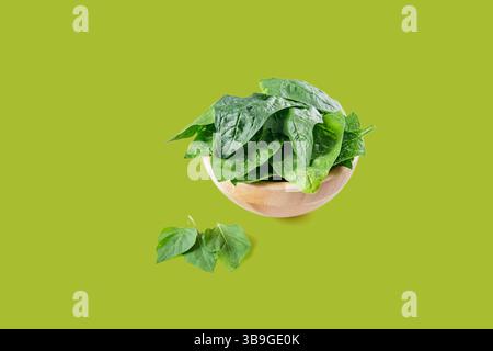Fresh spinach leaves are presented in a wooden bowl, emphasizing healthy eating and natural food Stock Photo