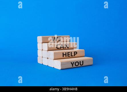 We can help you symbol. Concept words We can help you on wooden blocks. Beautiful blue background. Business and We can help you concept. Copy space Stock Photo