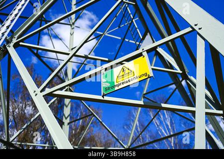 Sign on high-voltage pylon with inscription "Strompreissenkung", photomontage Stock Photo
