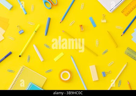 Back to school concept, school supplies and accessories on yellow background, notebook, pencils, paperclip, duster, flat lay copy space Stock Photo