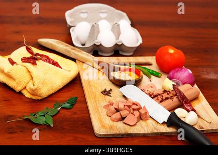 A vibrant and high-resolution image showcasing chopped sausages, fresh vegetables like tomato, onion, garlic, and green chili, along with assorted spi Stock Photo