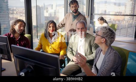 Business team analyzing data on computer in modern office Stock Photo