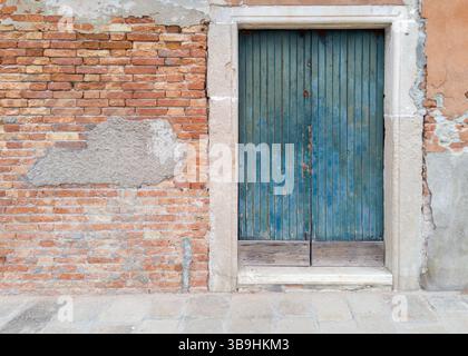 Old blue wooden door in brick wall Stock Photo
