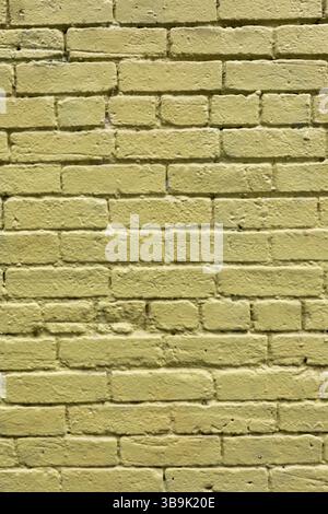 A close-up of a brick wall that has been painted yellow Stock Photo