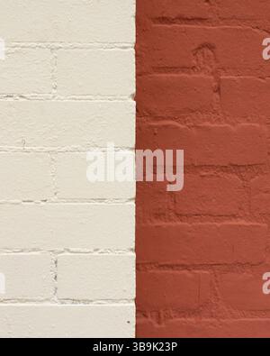 A close-up of two different brick walls, with one painted white and the other painted red. Stock Photo