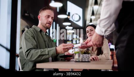 Celebrating In A Dark Restaurant, Paying Bill With Credit Card. Stock Photo