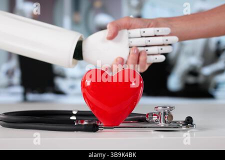Female Surgeon And Robotic Partner Shaking Hands In Hospital Setting. Stock Photo