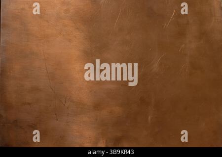 Copper backdrop. Scratched copper surface. Brass or copper background. Left natural lighting. Copy space. Stock Photo