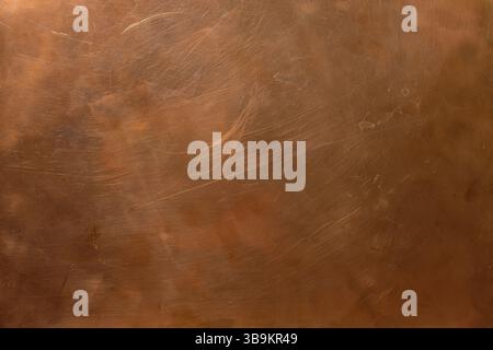 Copper backdrop. Scratched copper surface. Brass or copper background. Left natural lighting. Copy space. Stock Photo