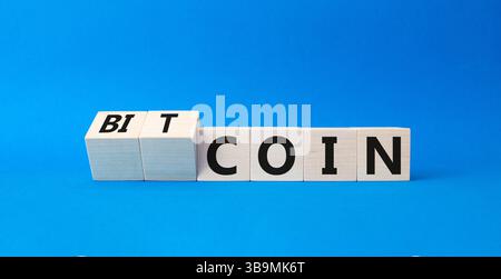 Bitcoin symbol. Turned wooden cubes with words Bitcoin and Coin. Beautiful blue background. Business and Bitcoin concept. Copy space Stock Photo