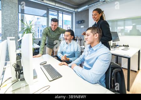 Diverse team of customer service representatives collaborating on a computer, providing support and solutions in a bright, modern office environment Stock Photo