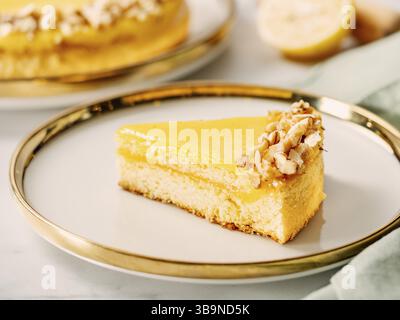 Piece of delicious lemon tart or lemon cake, modernly decorated with walnuts on aesthetic plate. Aesthetic of traditional classic french lemon pie wit Stock Photo