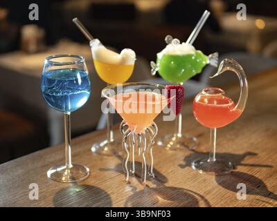 Set of different colorful alcoholic cocktails - margarita, blue lagoon, cosmopolitan and other. Set of various classic cocktails on bar counter backgr Stock Photo