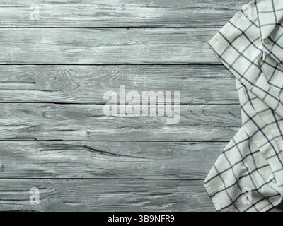 Gray wooden table with linen kitchen towel or textile napkin flat lay. Blue tablecloth on old gray wood tabletop. Copy space for text. Can use as mock Stock Photo