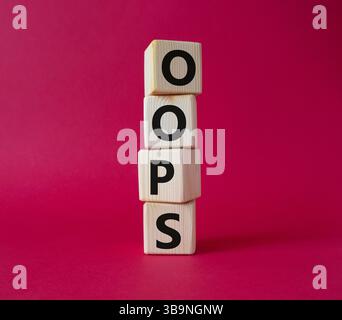 Oops symbol. Concept word Oops on wooden cubes. Beautiful red background. Business and Oops concept. Copy space. Stock Photo