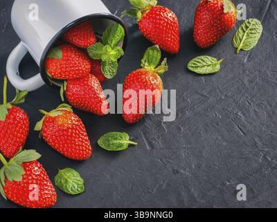 Fresh red strawberries on dark background. Strawberry in rustic cup on oriental black background. Top view or flat lay. Copyspace Stock Photo