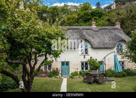 Cove cottage, in West Lulworth  is a Grade II listed building dating back to the 18th century, renowned for its picturesque thatched roof. Stock Photo