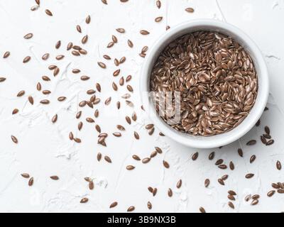 Flax seeds with copy space. Brown flax seed on white concrete textured background. Top view or flat lay. Copy space. Healthy food and diet concept Stock Photo