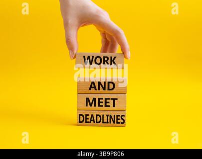 Work and deadline symbol. Concept words Work and meet deadlines on wooden blocks. Beautiful yellow background. Businessman hand. Business and Work and Stock Photo