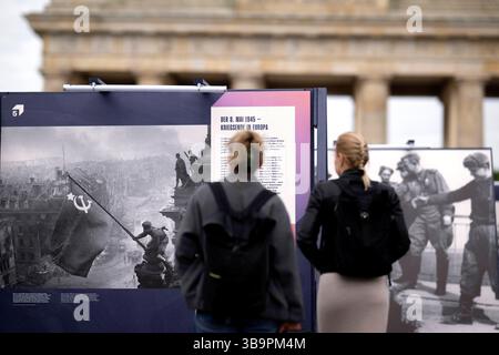 Ausstellung - 8.Mai Tag der Befreiung DEU, Deutschland, Germany, Berlin, 08.05.2025 Besucher vor einer Freiluftausstellung mit Fotografien darunter das Foto Rote Sowjetische Flagge auf dem Reichstag des sowjetischen Fotografen Jewgeni Chaldei und Foto Handschlag in Torgau als am 25. April 1945 US-Soldaten und Rotarmisten sich auf den Truemmern der Torgauer Elbbruecke begruessen welche zeigt Deutschland und Berlin in den letzten Tagen des Zweiten Weltkriegs zum Gedenken an den 80. Jahrestag der Befreiung am 8. und 9. Mai unter demTitel Endlich Frieden 80 Jahre nach dem Ende des Zweiten Weltkrie Stock Photo