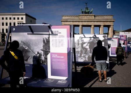 Ausstellung - 8.Mai Tag der Befreiung DEU, Deutschland, Germany, Berlin, 08.05.2025 Besucher vor einer Freiluftausstellung mit Fotografien darunter das Foto Rote Sowjetische Flagge auf dem Reichstag des sowjetischen Fotografen Jewgeni Chaldei und Foto Handschlag in Torgau als am 25. April 1945 US-Soldaten und Rotarmisten sich auf den Truemmern der Torgauer Elbbruecke begruessen welche zeigt Deutschland und Berlin in den letzten Tagen des Zweiten Weltkriegs zum Gedenken an den 80. Jahrestag der Befreiung am 8. und 9. Mai unter demTitel Endlich Frieden 80 Jahre nach dem Ende des Zweiten Weltkrie Stock Photo