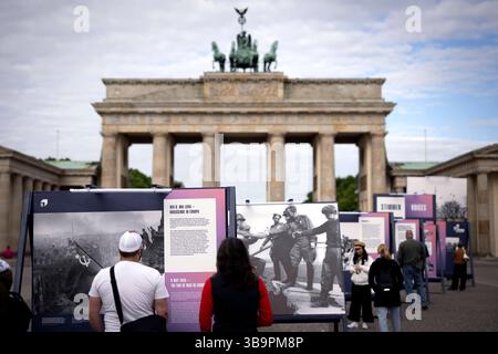 Ausstellung - 8.Mai Tag der Befreiung DEU, Deutschland, Germany, Berlin, 08.05.2025 Besucher vor einer Freiluftausstellung mit Fotografien darunter das Foto Rote Sowjetische Flagge auf dem Reichstag des sowjetischen Fotografen Jewgeni Chaldei und Foto Handschlag in Torgau als am 25. April 1945 US-Soldaten und Rotarmisten sich auf den Truemmern der Torgauer Elbbruecke begruessen welche zeigt Deutschland und Berlin in den letzten Tagen des Zweiten Weltkriegs zum Gedenken an den 80. Jahrestag der Befreiung am 8. und 9. Mai unter demTitel Endlich Frieden 80 Jahre nach dem Ende des Zweiten Weltkrie Stock Photo