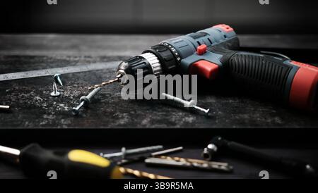 Carpenter Tools, Screws, And A Drill For Hanging Shelves On A Table Stock Photo