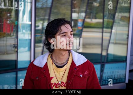 Young man looking aside in an urban atmosphere with a modern background building Stock Photo