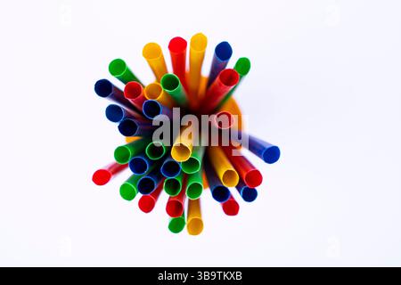 An isolated image of colorful drink straws for eco-friendly or party themes, Group of colorful straws standing in yellow container on white surface Stock Photo