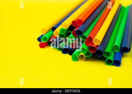 Colorful drink straws isolated in yellow-themed environment, ideal for food or drink ads. Stock Photo