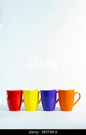 Bright Colorful Cups for Coffee or Tea on White Background,  Stacked tea or coffee cups in cheerful colors placed on a modern backdrop Stock Photo