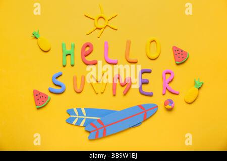 Text HELLO SUMMER made of plasticine and surfboards on orange background Stock Photo