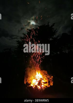 Large outdoor fire pit with flames and sparks Stock Photo